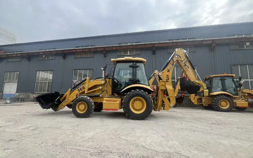 Real side view of YUYAN 366 backhoe loader in front of the workshop