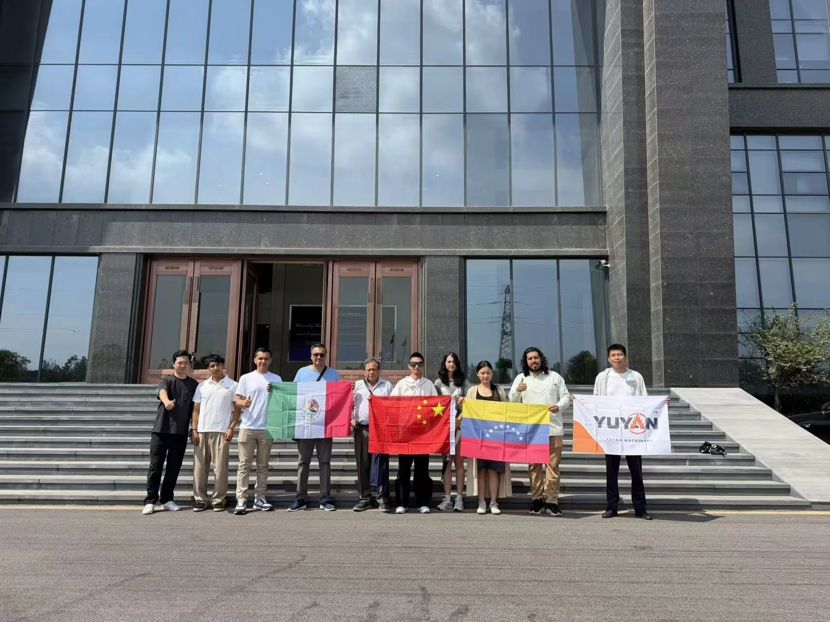 YUYAN customers and team posing outside the building with YUYAN banner